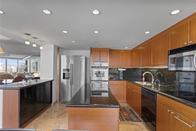 kitchen with a center island, dark stone countertops, a sink, black appliances, and backsplash