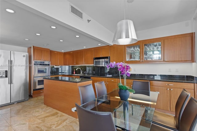 kitchen featuring stainless steel appliances, brown cabinets, and visible vents