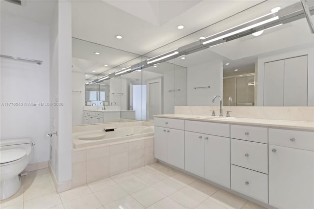 bathroom featuring a shower stall, toilet, vanity, a garden tub, and tile patterned flooring