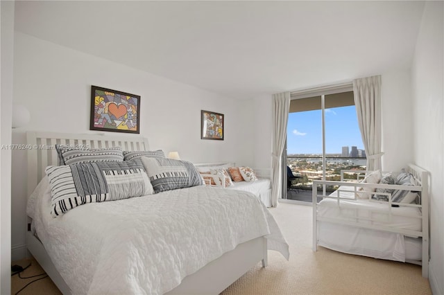 carpeted bedroom with access to outside and a city view