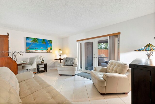 living room featuring french doors, baseboards, a textured ceiling, and light tile patterned floors