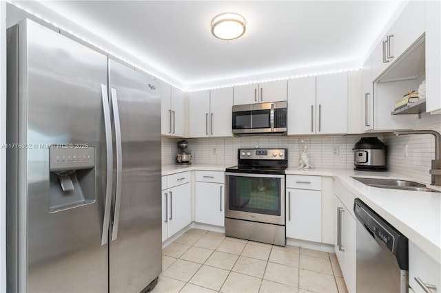 1250 S Miami Ave Unit 1206, Miami, FL 33130 - kitchen with stainless steel appliances, light countertops, decorative backsplash, light tile patterned floors, and white cabinetry