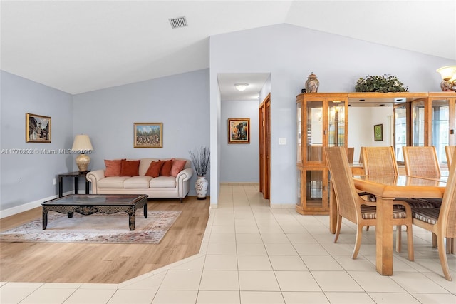 11472 SW 28th Ter, Miami, FL 33165 - living room featuring vaulted ceiling, baseboards, and light wood-type flooring