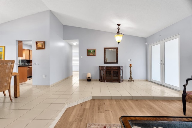 11472 SW 28th Ter, Miami, FL 33165 - unfurnished living room with vaulted ceiling, light wood-style floors, and baseboards