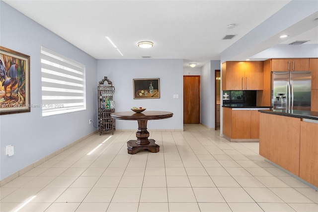 11472 SW 28th Ter, Miami, FL 33165 - kitchen with stainless steel refrigerator with ice dispenser, dark countertops, brown cabinets, tasteful backsplash, and baseboards