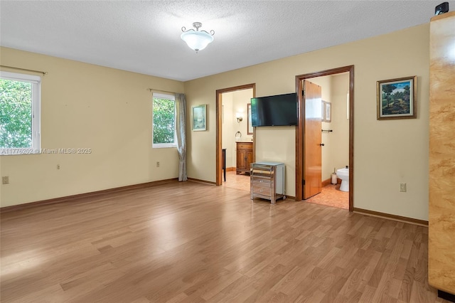 11472 SW 28th Ter, Miami, FL 33165 - unfurnished bedroom with light wood-style flooring, connected bathroom, and baseboards