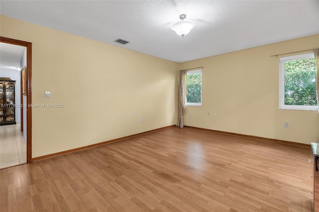 11472 SW 28th Ter, Miami, FL 33165 - unfurnished room with light wood finished floors, baseboards, and a textured ceiling