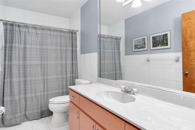 11472 SW 28th Ter, Miami, FL 33165 - full bathroom featuring tile walls, toilet, tile patterned floors, vanity, and wainscoting