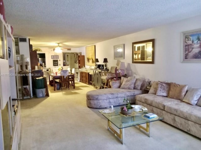 living room with a textured ceiling, a ceiling fan, light carpet, and visible vents