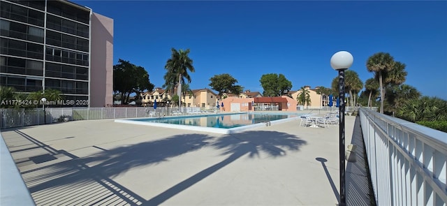 pool with fence and a patio area