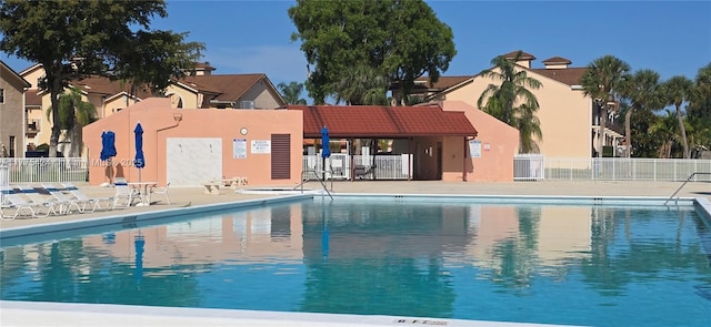 community pool with fence and a patio area