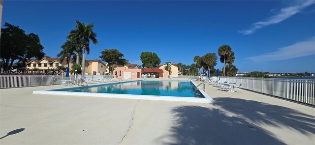 community pool featuring fence and a patio area