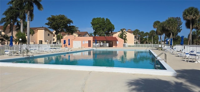 pool with a residential view, a patio area, and fence