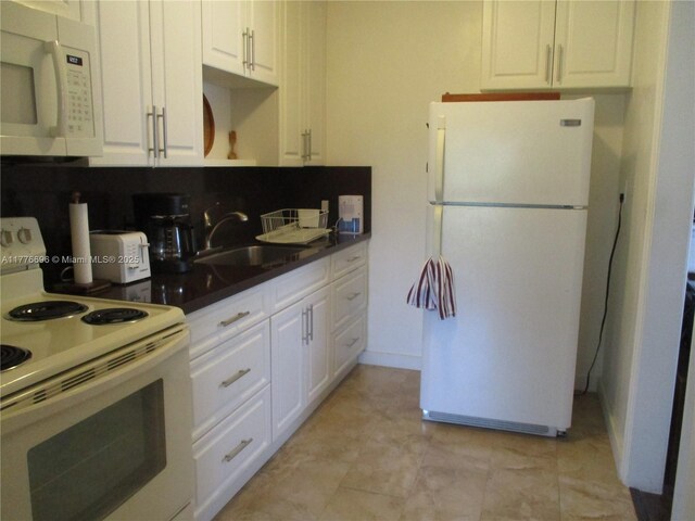 105 NW 32nd Pl, Miami, FL 33125 - kitchen featuring white appliances, a sink, white cabinets, and dark countertops