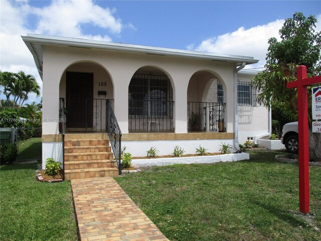 105 NW 32nd Pl, Miami, FL 33125 - view of front of home with a porch and stucco siding