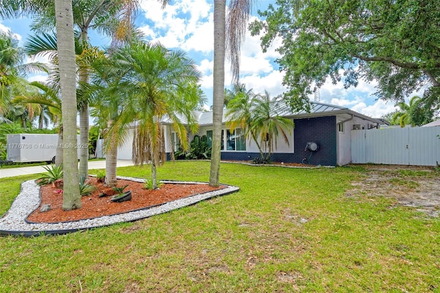 view of yard featuring concrete driveway, a gate, and fence