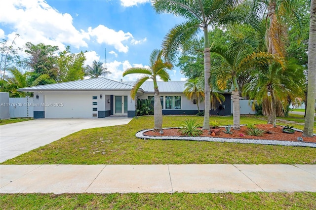 ranch-style house featuring fence, a garage, concrete driveway, a front yard, and french doors