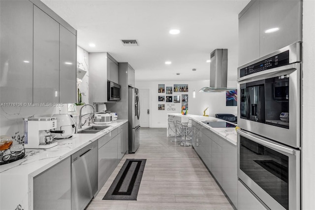 kitchen with modern cabinets, gray cabinets, island exhaust hood, and appliances with stainless steel finishes