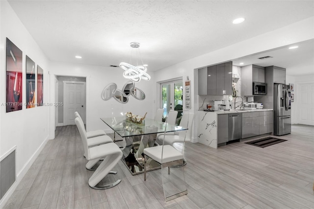 dining area featuring visible vents, light wood-style flooring, an inviting chandelier, and recessed lighting
