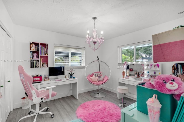 office featuring baseboards, wood finished floors, an inviting chandelier, and plenty of natural light