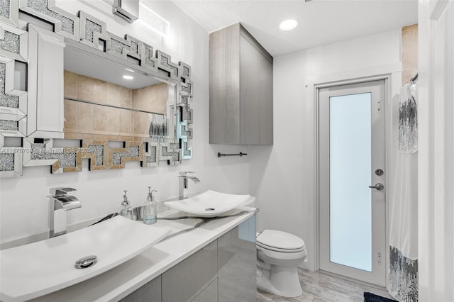 full bathroom with vanity, toilet, and tiled shower