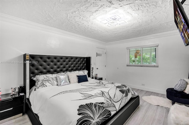 bedroom with a textured ceiling, ornamental molding, baseboards, and light wood finished floors