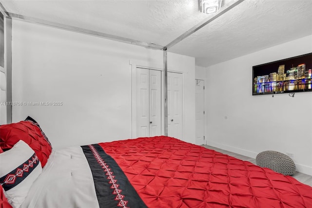 bedroom featuring baseboards, a closet, and a textured ceiling