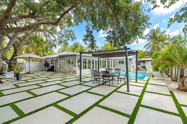 rear view of property featuring a patio, fence, and a fenced in pool