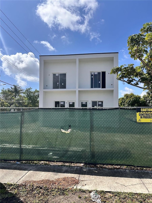 exterior space featuring stucco siding and fence