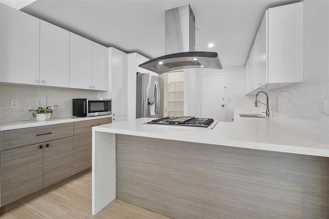 700 Biltmore Way Unit 402, Coral Gables, FL 33134 - kitchen featuring island range hood, appliances with stainless steel finishes, a sink, a peninsula, and tasteful backsplash