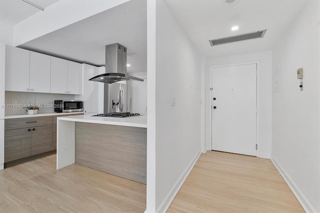 700 Biltmore Way Unit 402, Coral Gables, FL 33134 - kitchen with stainless steel appliances, island exhaust hood, light wood-style flooring, light countertops, and baseboards