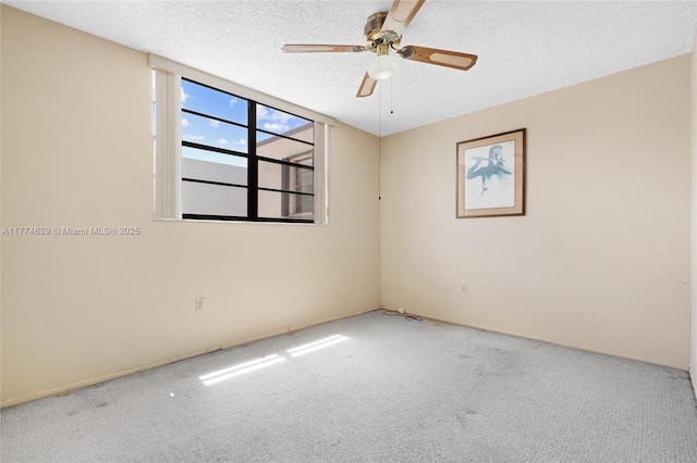 carpeted spare room with ceiling fan and a textured ceiling