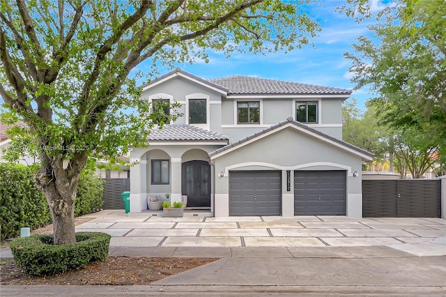 view of front of house featuring french doors, a tile roof, concrete driveway, and stucco siding
