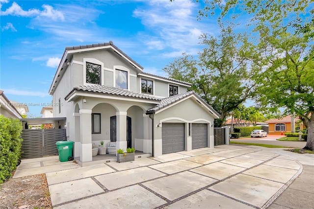 view of front of house featuring stucco siding, a tile roof, concrete driveway, and an attached garage