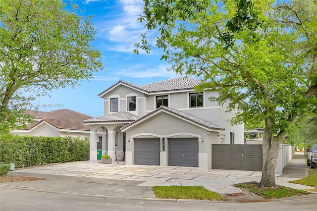 view of front facade featuring driveway, stucco siding, fence, an attached garage, and a tiled roof