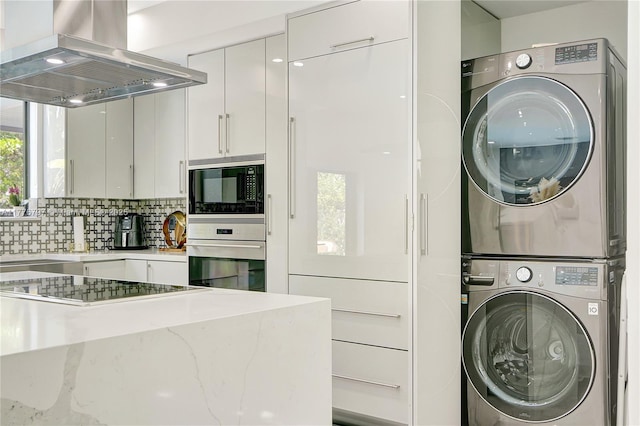 clothes washing area with a sink, laundry area, and stacked washer / drying machine