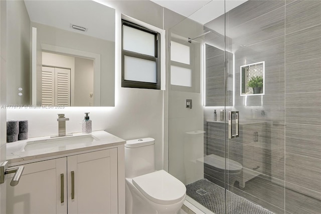 bathroom with toilet, vanity, a stall shower, and visible vents