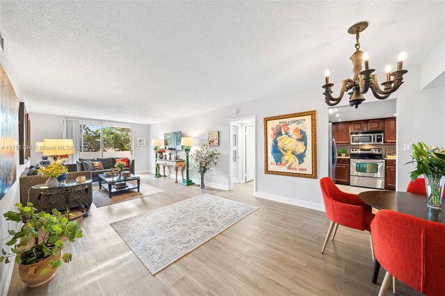 13131 Ixora Ct Unit A-1 A-2 A-3, North Miami, FL 33181 - living room with light wood-style floors, an inviting chandelier, baseboards, and a textured ceiling