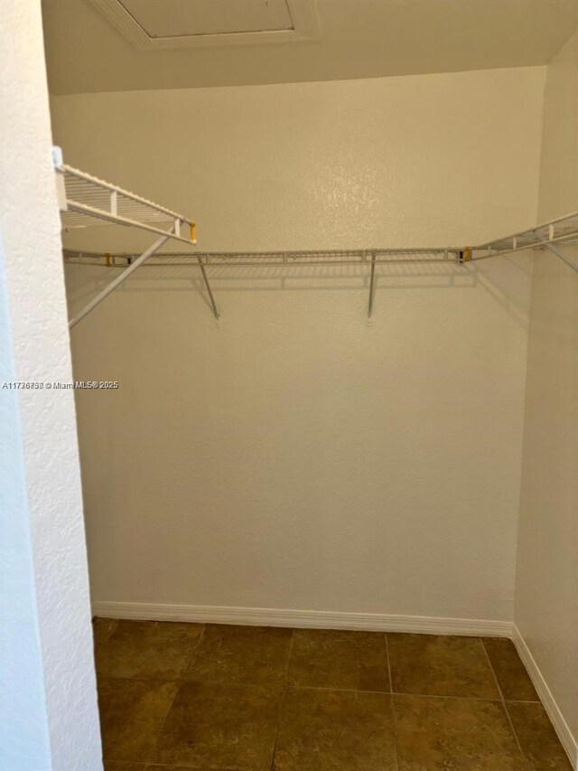 2062 NE 167th St Unit 3-112, North Miami Beach, FL 33162 - spacious closet featuring dark tile patterned flooring