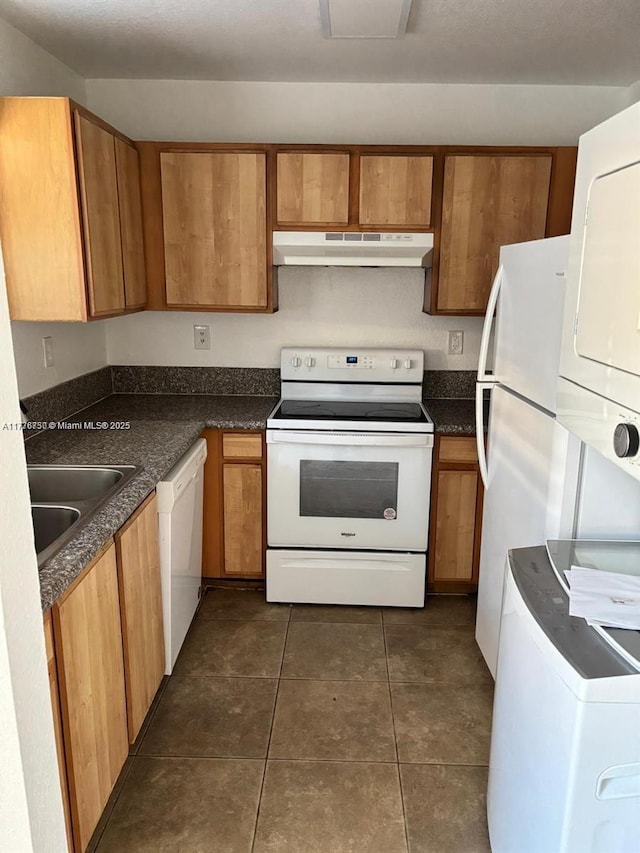 2062 NE 167th St Unit 3-112, North Miami Beach, FL 33162 - kitchen with white appliances, under cabinet range hood, a sink, estacked washer and dryer, and dark countertops