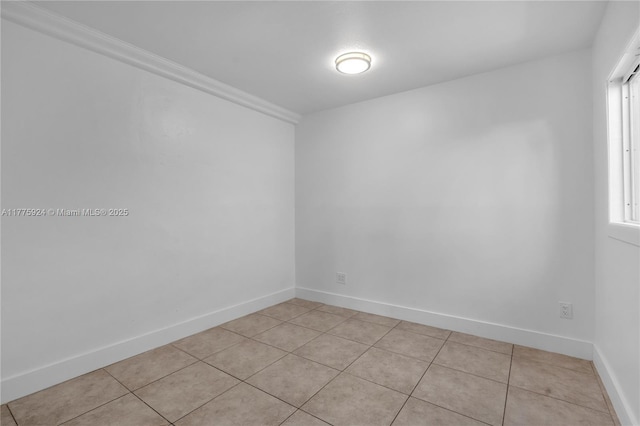 spare room featuring plenty of natural light, baseboards, and light tile patterned floors
