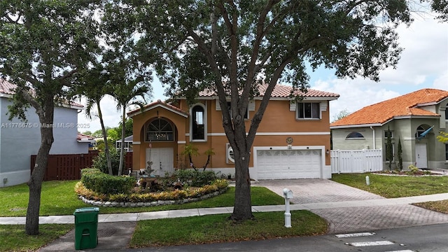 view of front of home with a tile roof, decorative driveway, fence, and stucco siding
