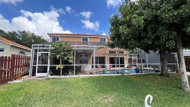 rear view of house with stucco siding, a fenced backyard, a balcony, a lanai, and a yard