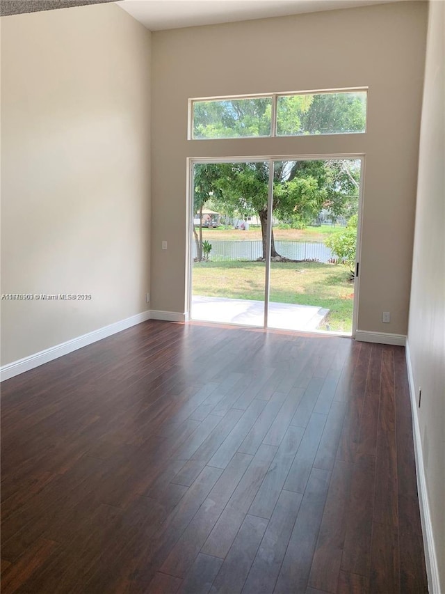 10521 SW 13th Ct, Pembroke Pines, FL 33025 - spare room with a wealth of natural light, dark wood-style floors, and baseboards