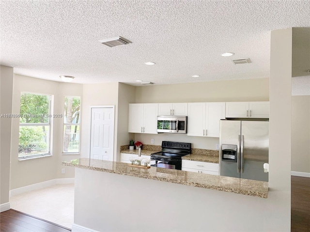 10521 SW 13th Ct, Pembroke Pines, FL 33025 - kitchen with white cabinets, appliances with stainless steel finishes, wood finished floors, and visible vents
