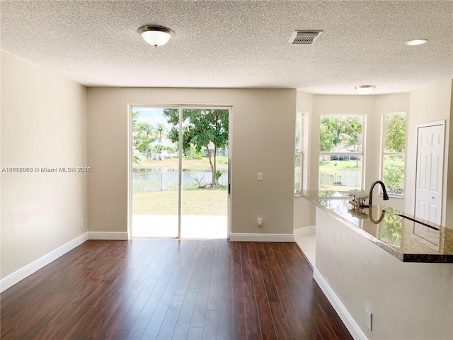 10521 SW 13th Ct, Pembroke Pines, FL 33025 - spare room featuring dark wood-type flooring, visible vents, baseboards, and a textured ceiling