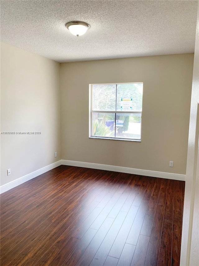 10521 SW 13th Ct, Pembroke Pines, FL 33025 - spare room featuring a textured ceiling, baseboards, and dark wood-style floors