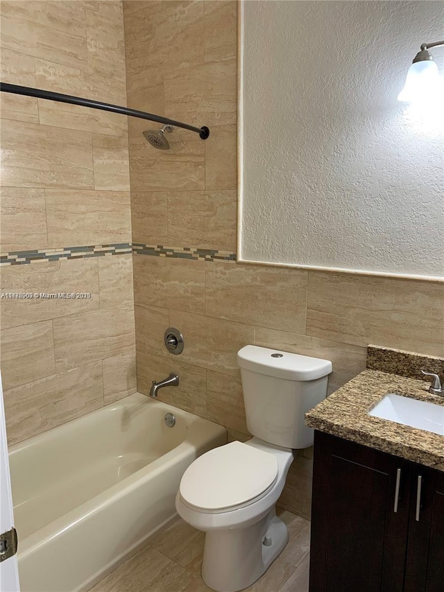 10521 SW 13th Ct, Pembroke Pines, FL 33025 - full bathroom with vanity, toilet, washtub / shower combination, tile walls, and a textured wall