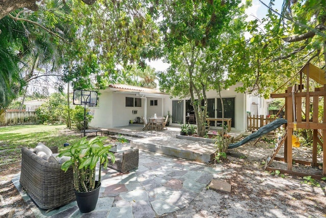 10619 NE 10th Pl, Miami Shores, FL 33138 - back of house featuring stucco siding, a playground, and a patio