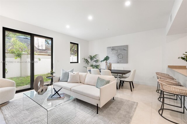 living room with light tile patterned flooring, visible vents, and recessed lighting